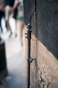 Close-up of metal railing against wall in city