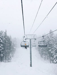 Person wearing yellow riding ski lift alone