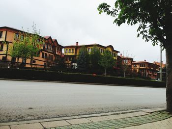 Buildings by street against sky