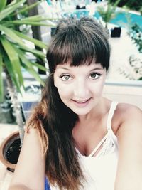 Portrait of young woman smiling while standing outdoors