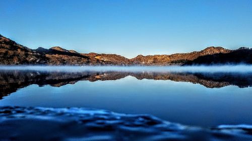 Scenic view of lake against clear blue sky