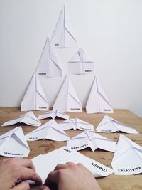Cropped image of hand folding  paper airplanes
