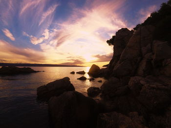 Scenic view of sea and rock formations at sunset