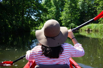 Rear view of woman paddeling on lake