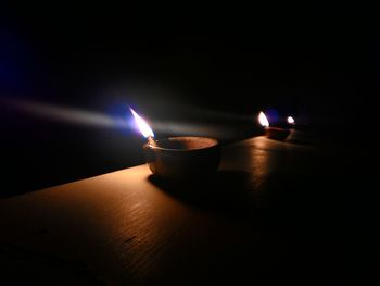 View of lit candle in dark room