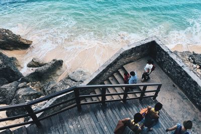 High angle view of people walking on steps by beach