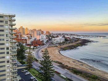 High angle view of street by buildings against sky during sunset