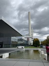 Road by factory against sky