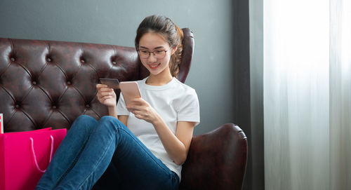 Young woman sitting on sofa at home