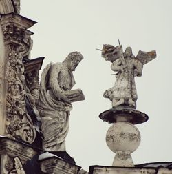 Low angle view of angel statue against sky