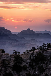 Scenic view of mountains against orange sky