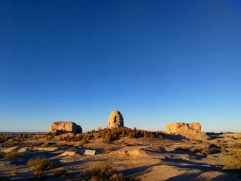 Rock formations against clear blue sky