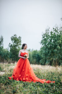 Woman in wedding dress on field