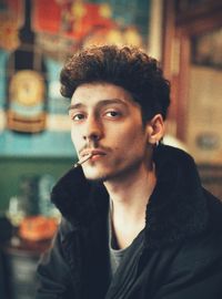 Portrait of young man looking away and smoking a cigarette 