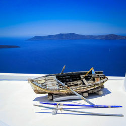 Boat on shore against calm blue sea