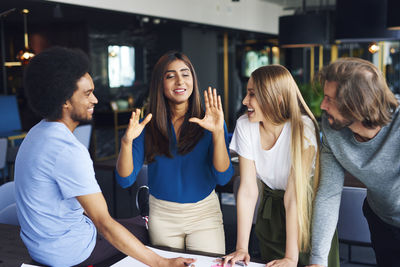 Smiling coworkers discussing during meeting in office