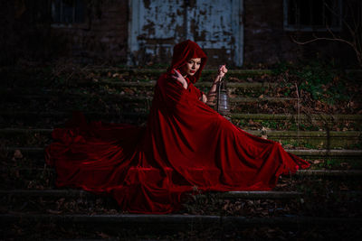 Woman with red umbrella standing on land