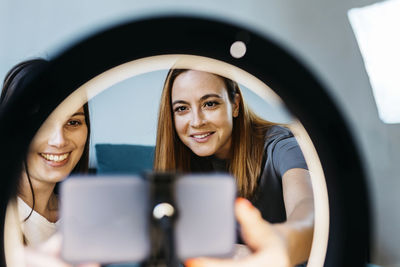 Portrait of a smiling young woman using phone