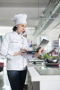 Female chef using laptop in kitchen