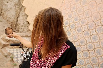 Rear view of woman standing against wall