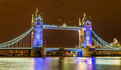 Illuminated bridge over river at night