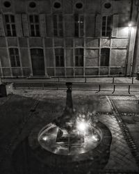 Reflection of illuminated building on street at night