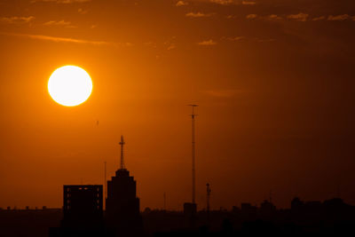 Silhouette buildings against sky during sunset
