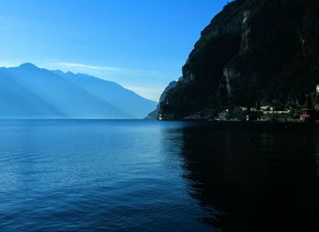 Scenic view of sea and mountains against blue sky