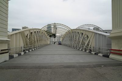 Footbridge amidst buildings in city against sky