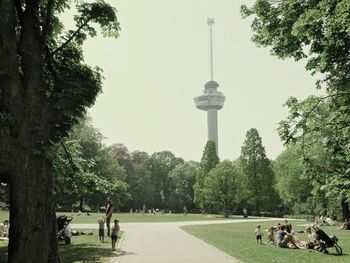 People relaxing in park against clear sky