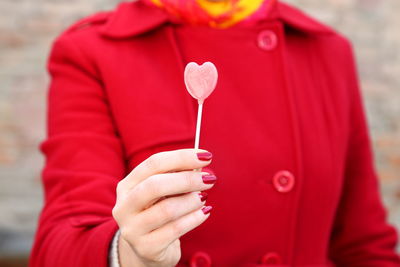 Midsection of woman holding lollipop