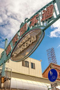 Low angle view of text on building against sky