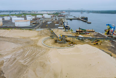 High angle view of industry by sea against sky