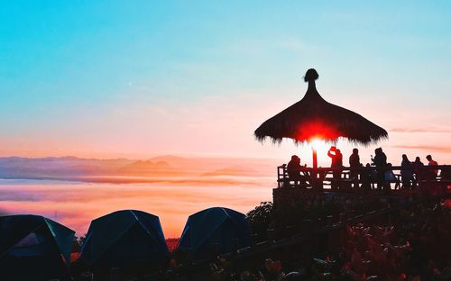 Silhouette people against sky during sunset