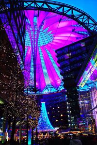 Low angle view of illuminated ferris wheel in the dark