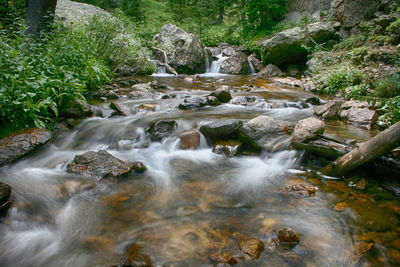 High angle view of stream flowing through rocks