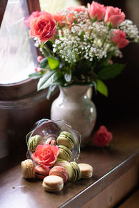 Still life on the windowsill, flowers and macaroons, pink roses, colorful candys
