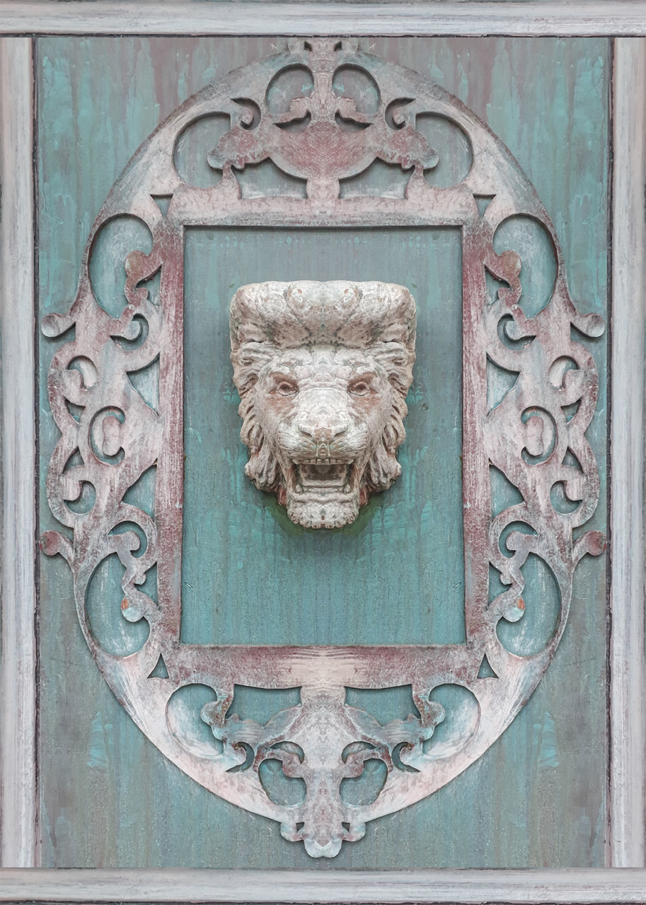 CLOSE-UP OF OLD DOOR KNOCKER ON WOODEN WALL