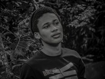 Portrait of young man standing against plants