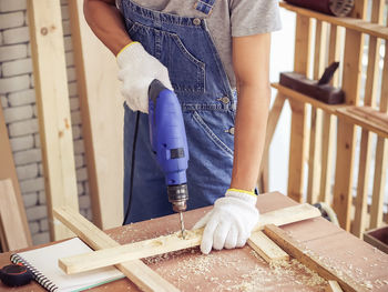 Midsection of carpenter working in workshop