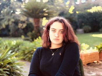 Portrait of young woman sitting outdoors