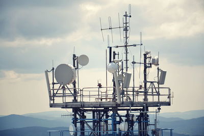 Communications tower against cloudy sky