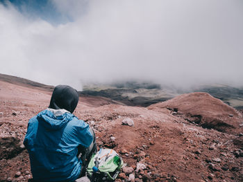 Rear view of man looking at mountain against sky