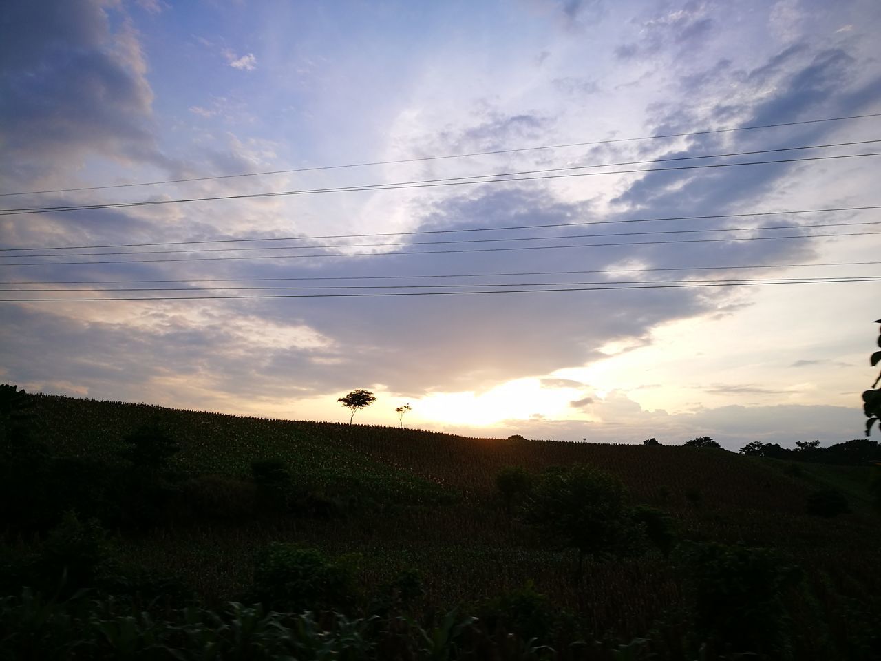 SILHOUETTE LANDSCAPE AGAINST CLOUDY SKY DURING SUNSET