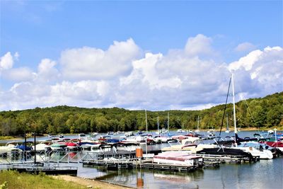 Boats moored at harbor against sky