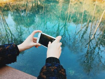 Close-up of hand photographing water