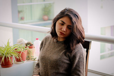 Beautiful woman sitting on table at home