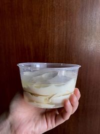 Midsection of person holding ice cream in glass