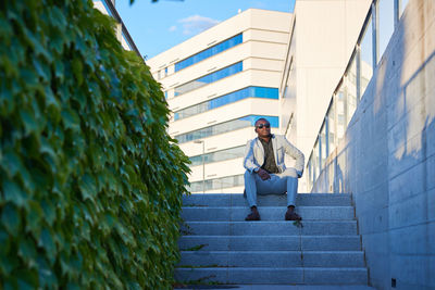 Elegant african-american sitting on the steps of a park.