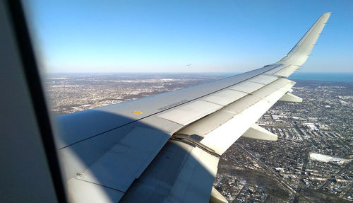 Aerial view of airplane wing against clear sky